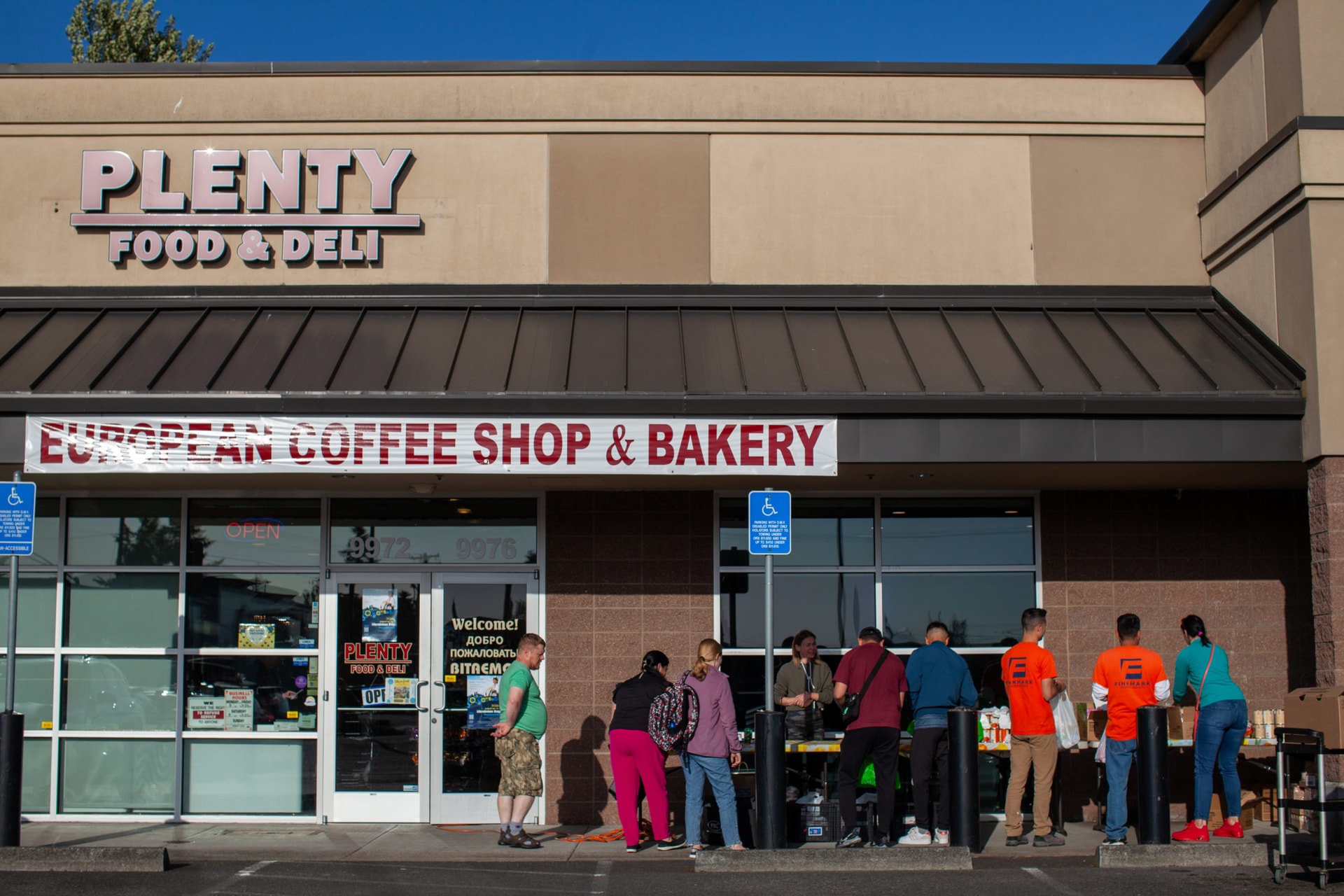 A line of individuals and families wait outside Plenty Food and Deli, an Eastern European market in Portland, Oregon, where the Community Pulse Association runs a weekly food distribution for Eastern European families. The partnership with Oregon Food Bank helps ensure that communities have access to culturally-appropriate food.