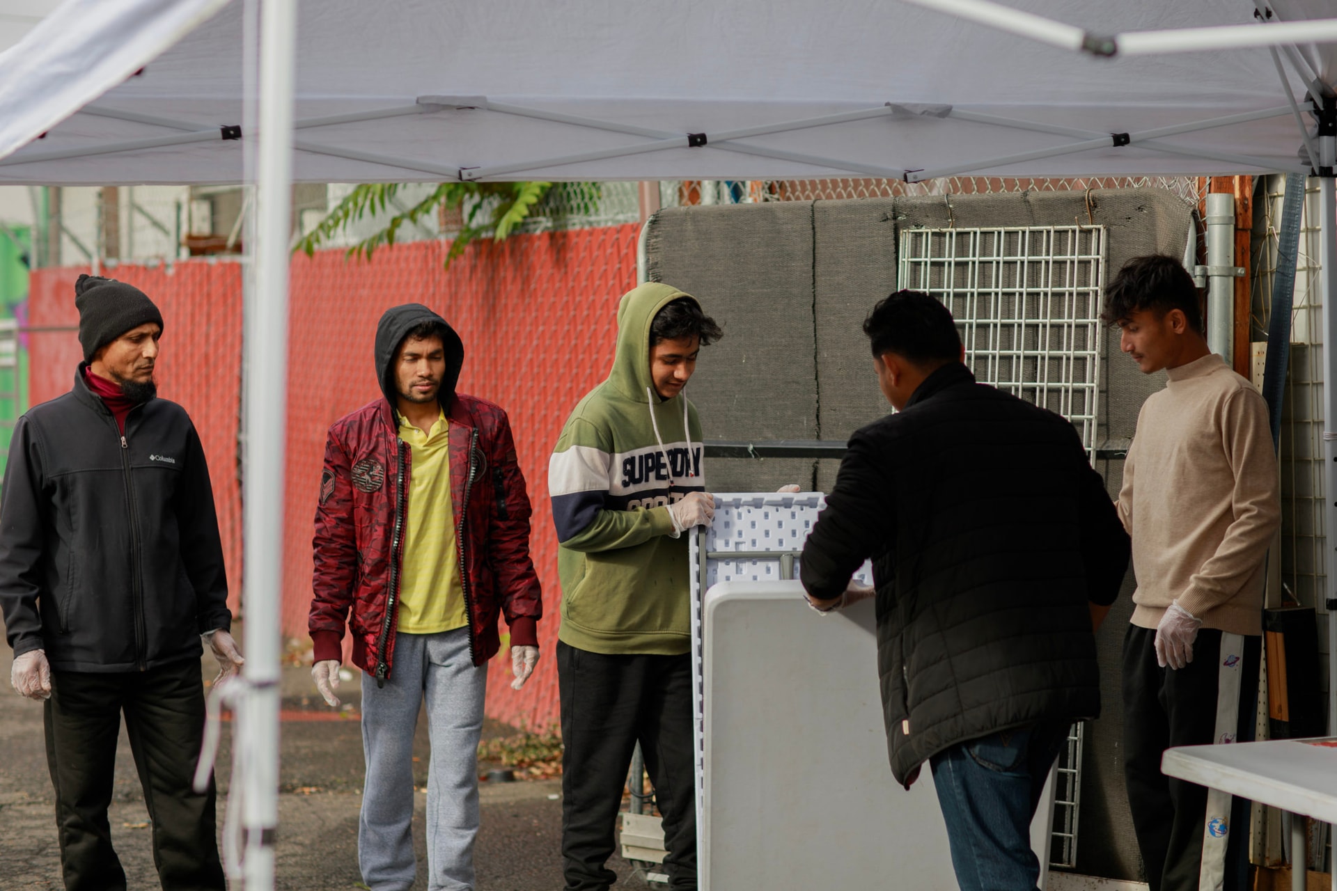 A group of BIPOC young men prepare food for distribution at Yadanar Halal Market, a community hub serving Asian, Middle Eastern, and African communities. This monthly free food distribution, in partnership with Oregon Food Bank, ensures individuals experiencing hunger have access to culturally-relevant groceries, supporting food security across diverse communities in Portland.